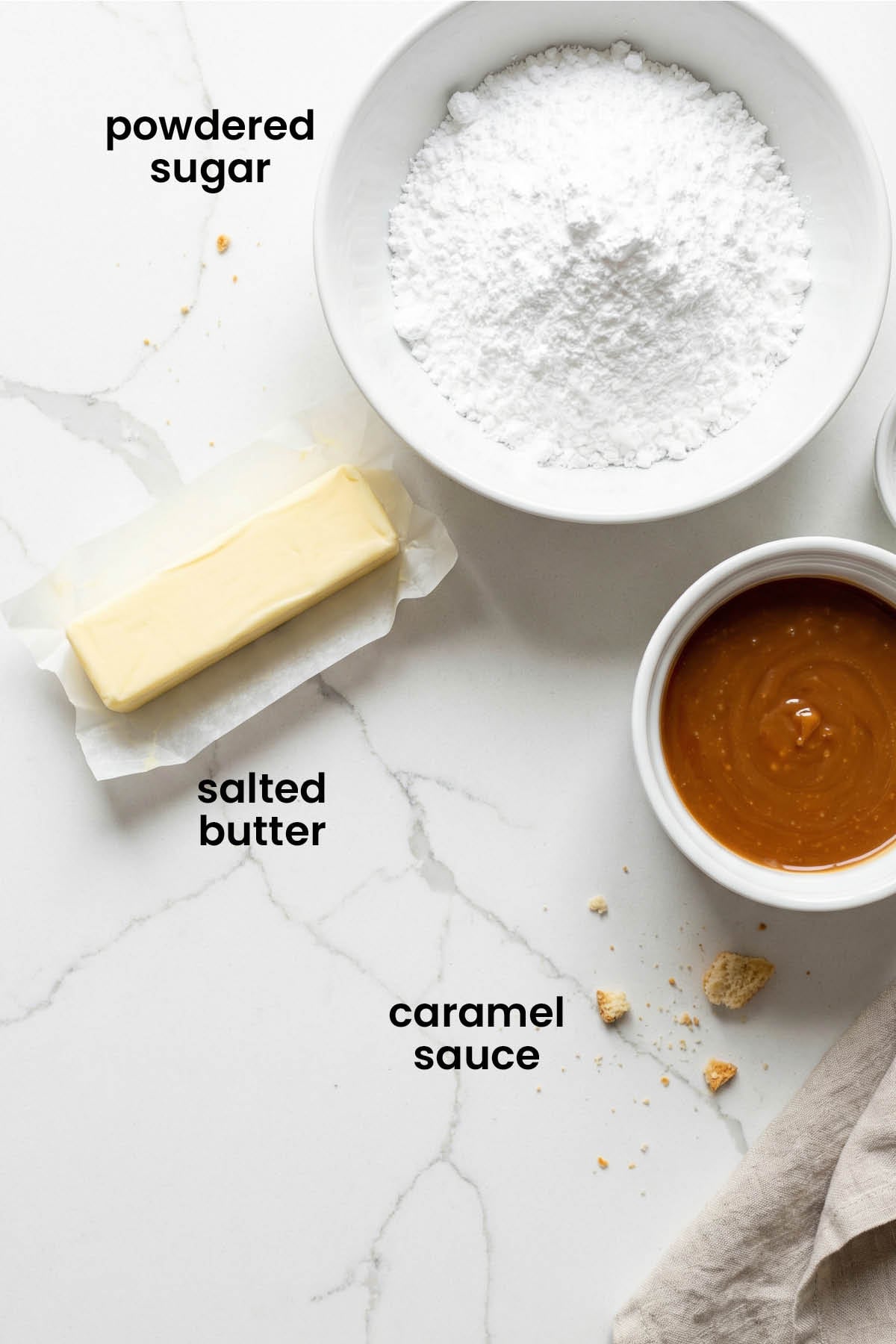 individual ingredients for caramel buttercream frosting laid out against a white background.