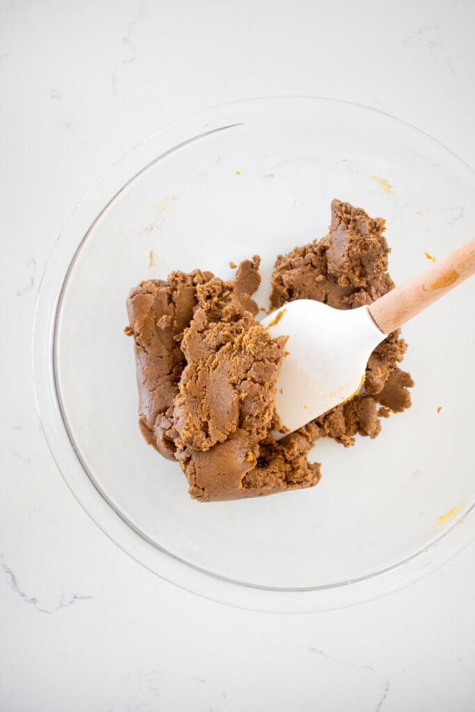 mushroom peanut butter dog treat dough mixed up in a glass bowl on a white countertop.