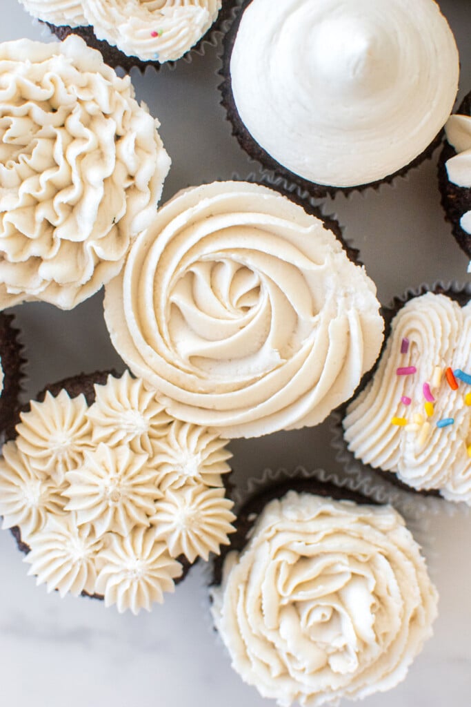 chocolate cupcakes with vanilla buttercream frosting frosted different ways on many cupcakes.