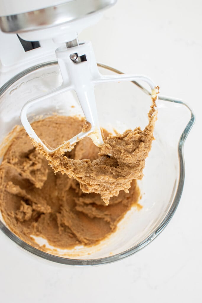 creamed butter and sugar together in a glass mixing bowl on a white marble countertop.