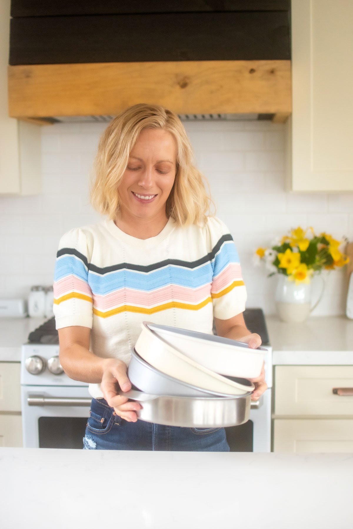 woman holding nontoxic cake pans in kitchen