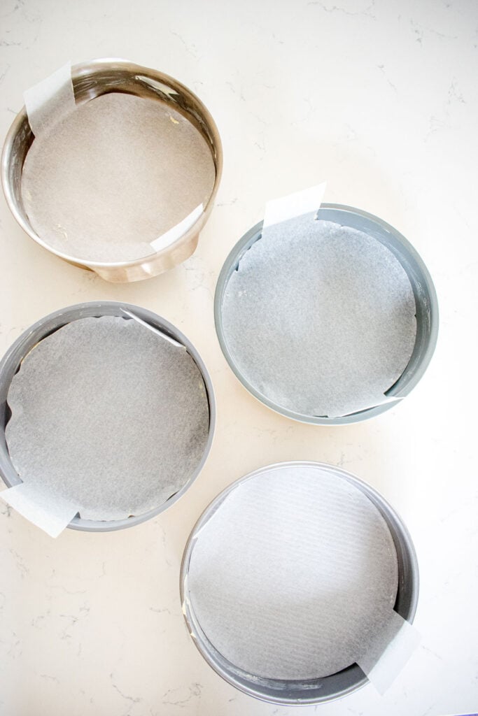 nontoxic cake pans lined with parchment paper sitting on the counter.