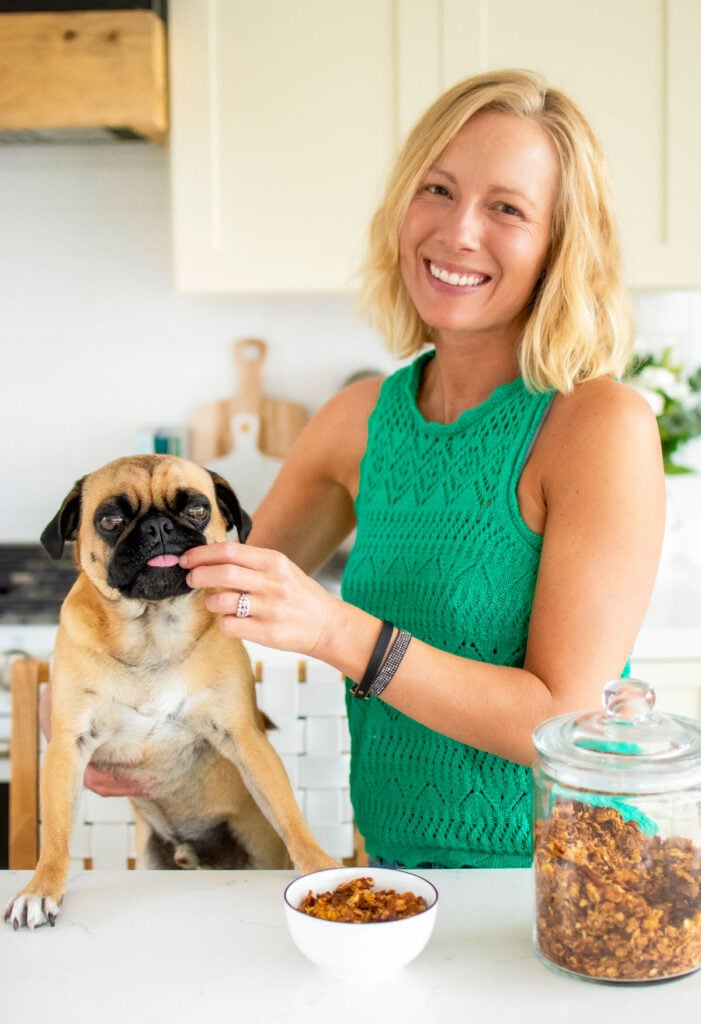 woman and pug in the kitchen eating granola
