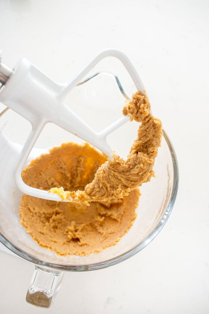 brown sugar and butter creamed together in a glass mixing bowl on a marble counter.
