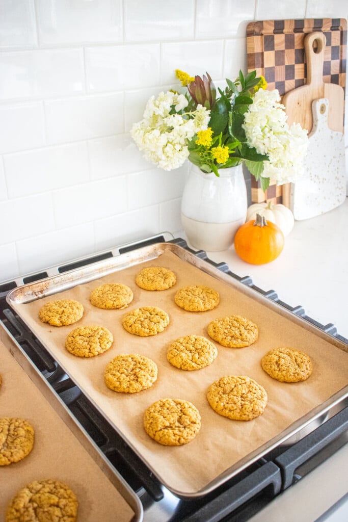 pumpkin spice cookies cooling on a baking sheet on top of an oven.