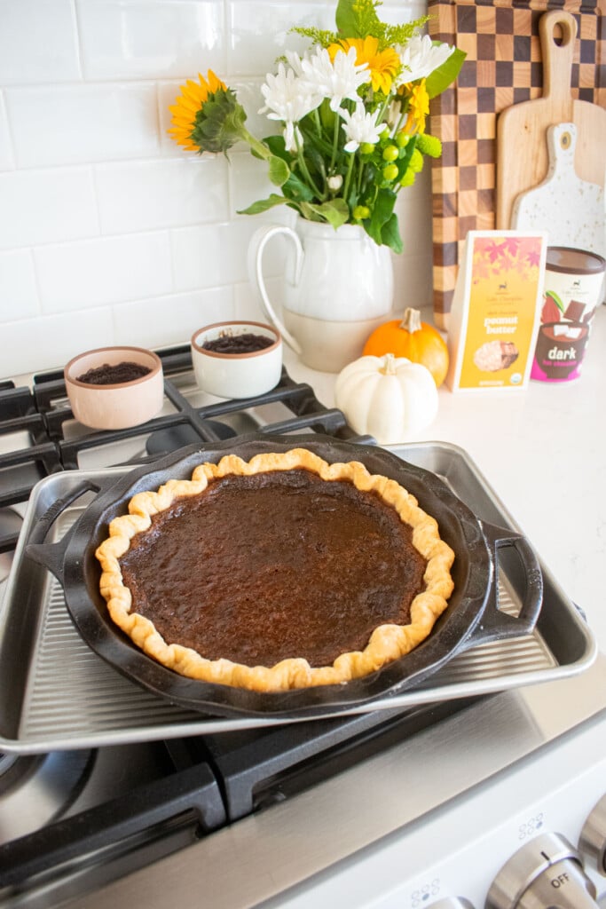 baked chocolate pumpkin pie without eggs on a baking sheet cooling on a stovetop.