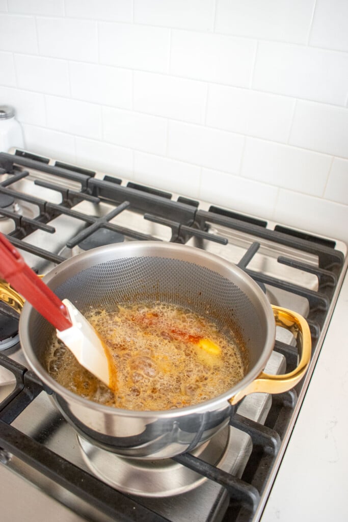 gingerbread caramel sauce being made in a titanium pot on the stovetop.