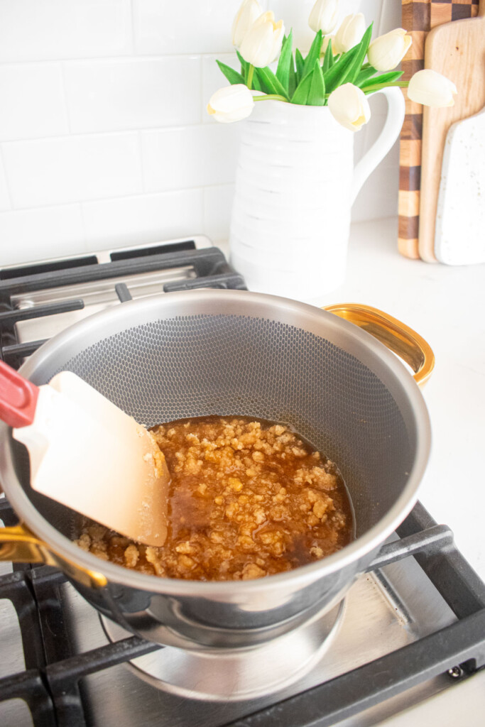 cane sugar being melted in a pot on a stovetop.