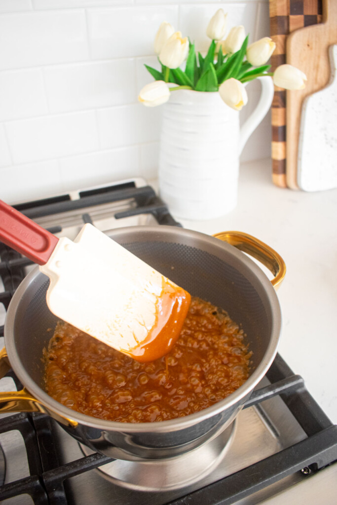 homemade caramel being cooked in a pot on the stovetop.