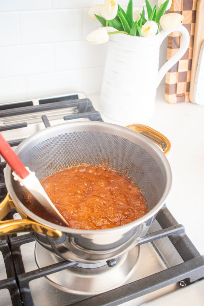 homemade caramel sauce with bone broth being cooked on the stovetop in a titanium pot.