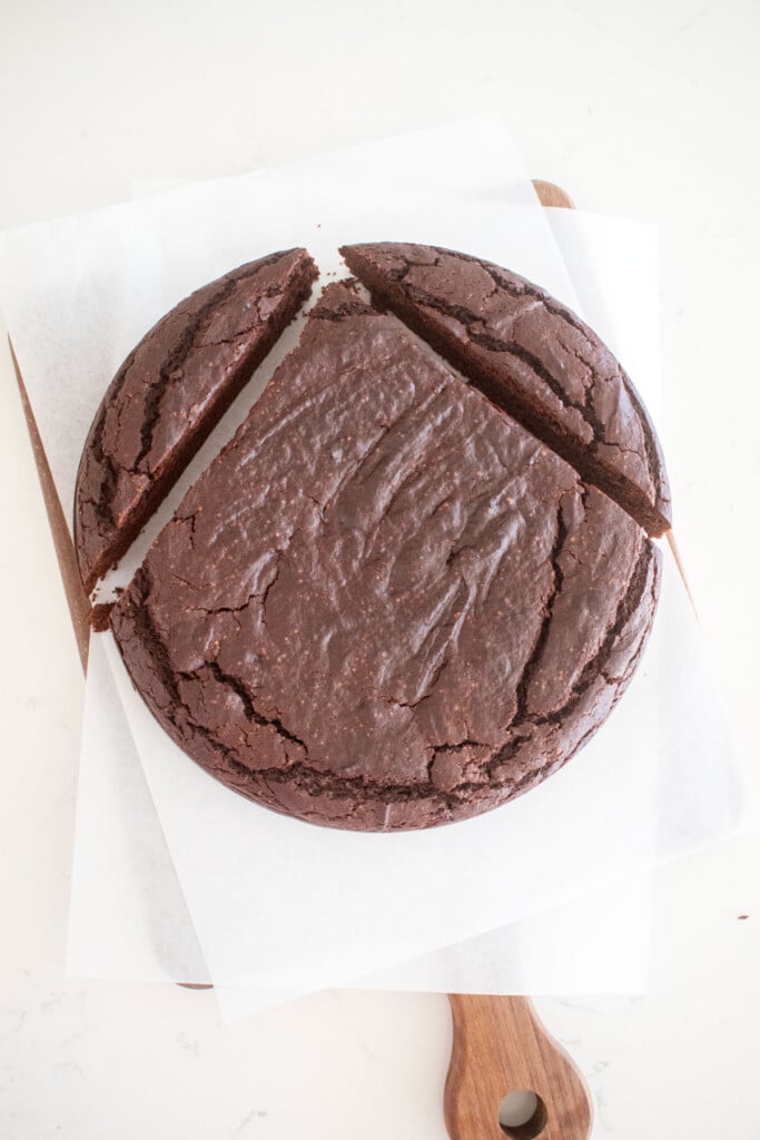 round eggless chocolate cake with the top parts of cake cut like an upside down v.