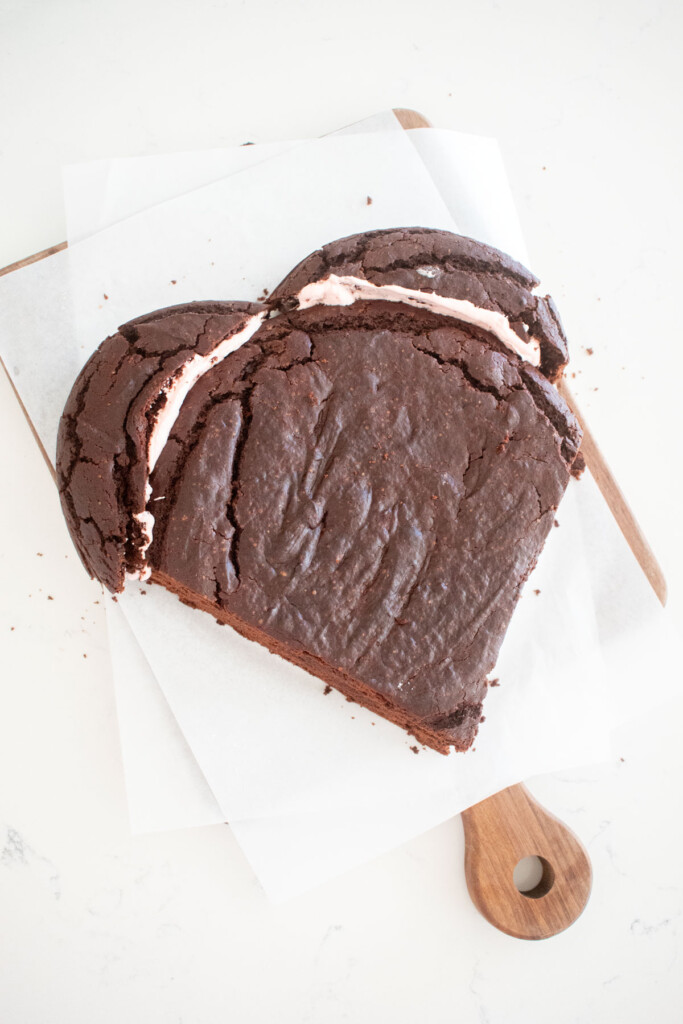 eggless chocolate cake formed into the shape of a heart on a white marble counter.