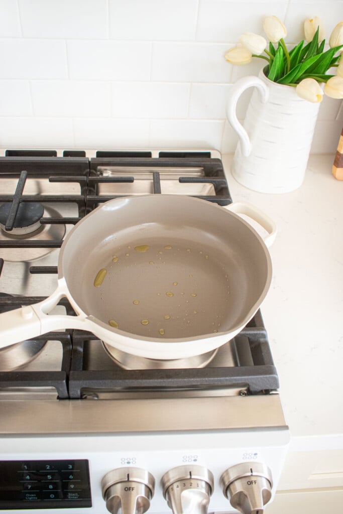 large skillet on the stovetop with olive oil in it.