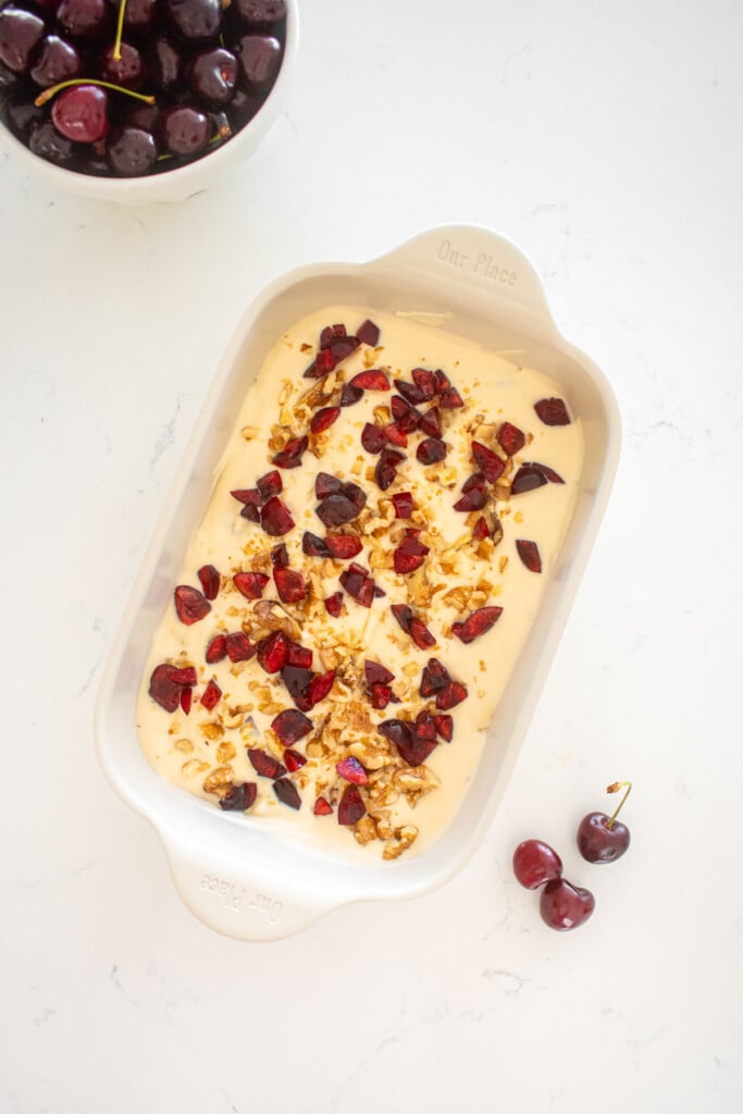 palmer house ice cream in a baking dish on a marble counter with a bowl of cherries.