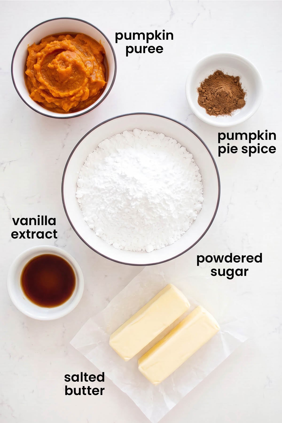 individual ingredients for pumpkin spice buttercream frosting laid out against a white background.