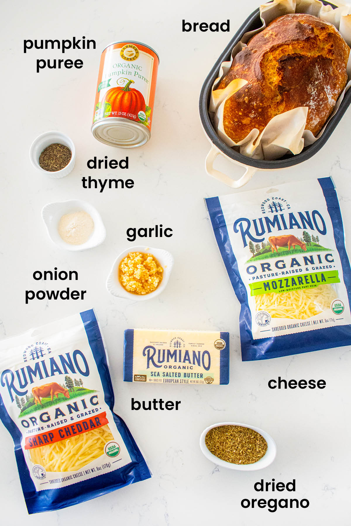 individual ingredients for cheesy pumpkin garlic bread laid out against a white background.