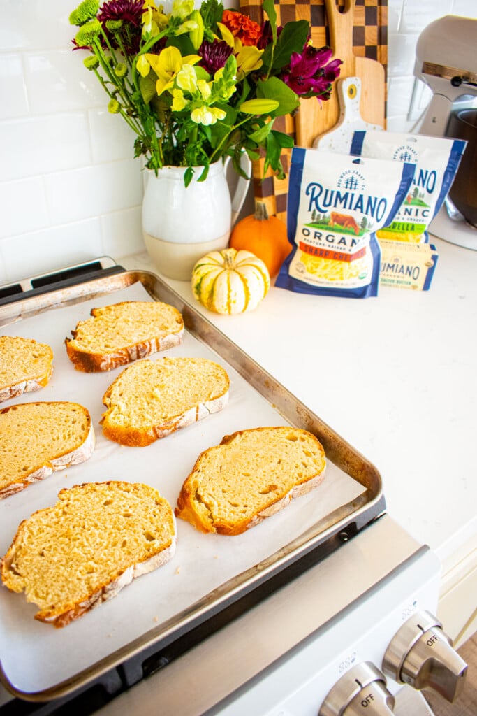 baking sheet with slices of sourdough bread on top of an oven.