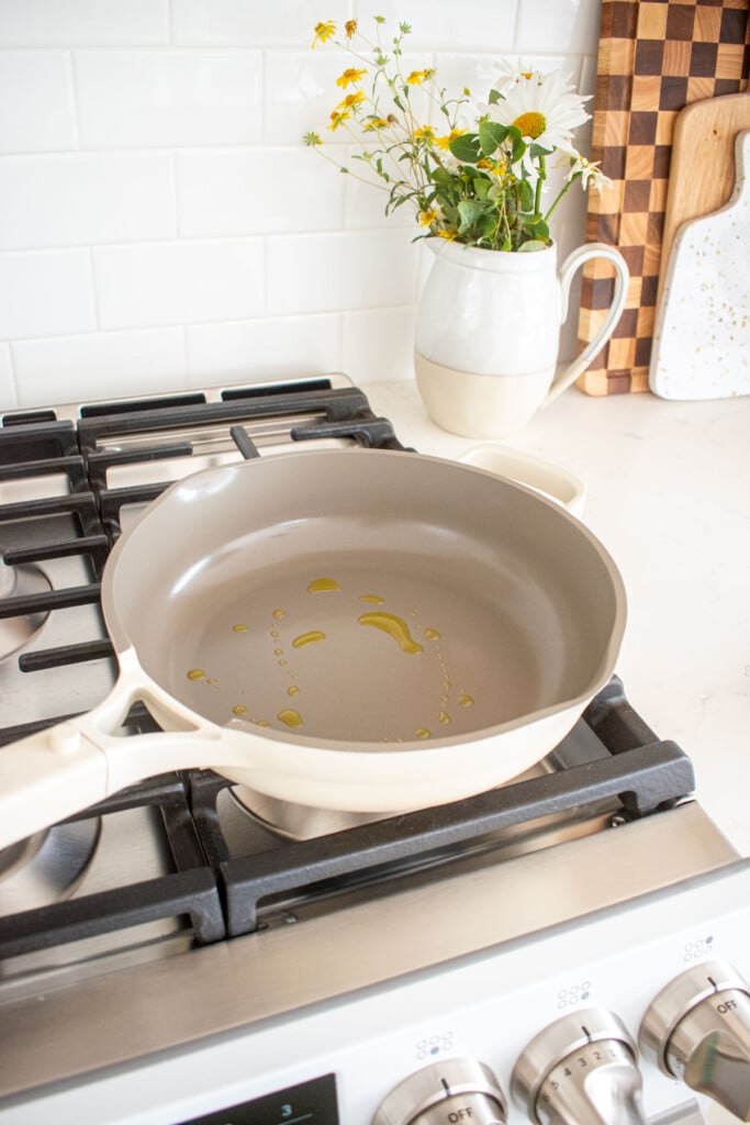 large skillet on a stovetop with olive oil in it.