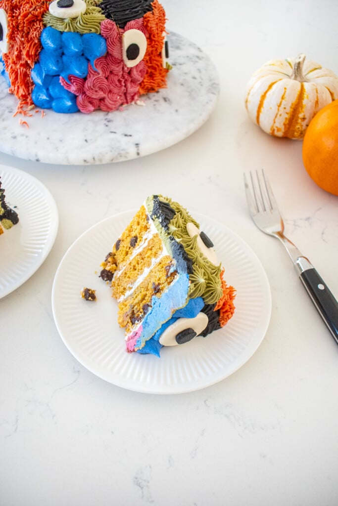 slice of pumpkin chocolate chip monster cake on a plate on a marble counter.